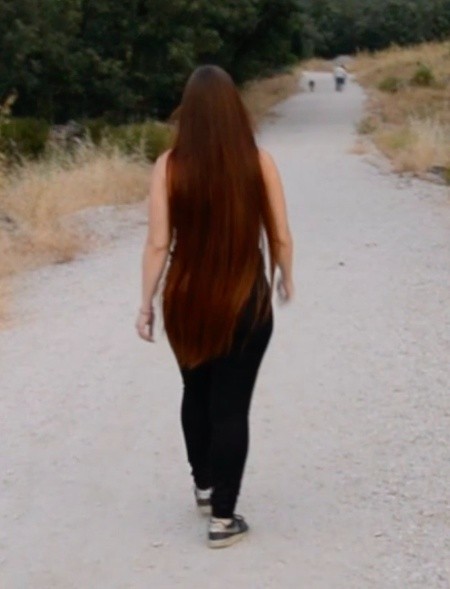 VIDEO - Thigh length hair lady walking outside