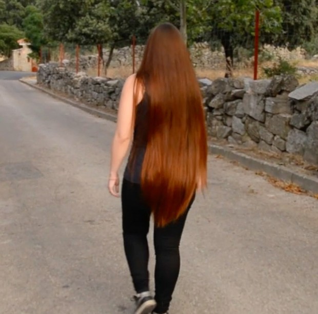 VIDEO - Thigh length hair lady walking outside