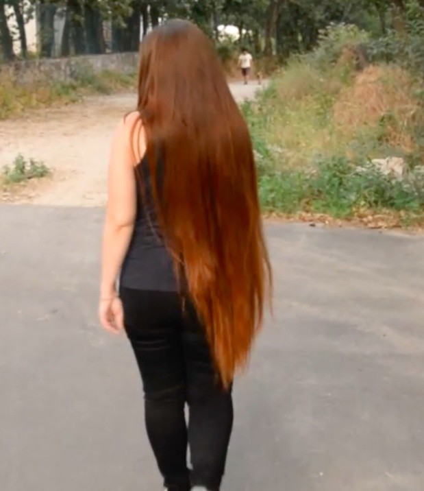 VIDEO - Thigh length hair lady walking outside